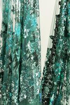 The image is a close-up of a fabric with a green and blue pattern, featuring a mix of metallic and organic textures.