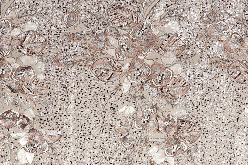 a close-up view of a fabric with a floral pattern. The fabric appears to be made of a material with a beige or brown color, and it has a textured appearance. The pattern consists of various flowers and leaves, some of which are intricately detailed, creating a visually appealing and detailed design.