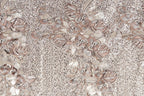 a close-up view of a fabric with a floral pattern. The fabric appears to be made of a material with a beige or brown color, and it has a textured appearance. The pattern consists of various flowers and leaves, some of which are intricately detailed, creating a visually appealing and detailed design.
