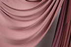 a close-up view of a soft, flowing pink fabric, possibly a curtain or textile. The fabric has a smooth, wavy texture and appears to be made of a soft, plush material. The image does not contain any discernible objects or actions, and there are no specific actions or objects that can be described in detail. The image is a simple, uncluttered composition that focuses on the texture and color of the fabric.