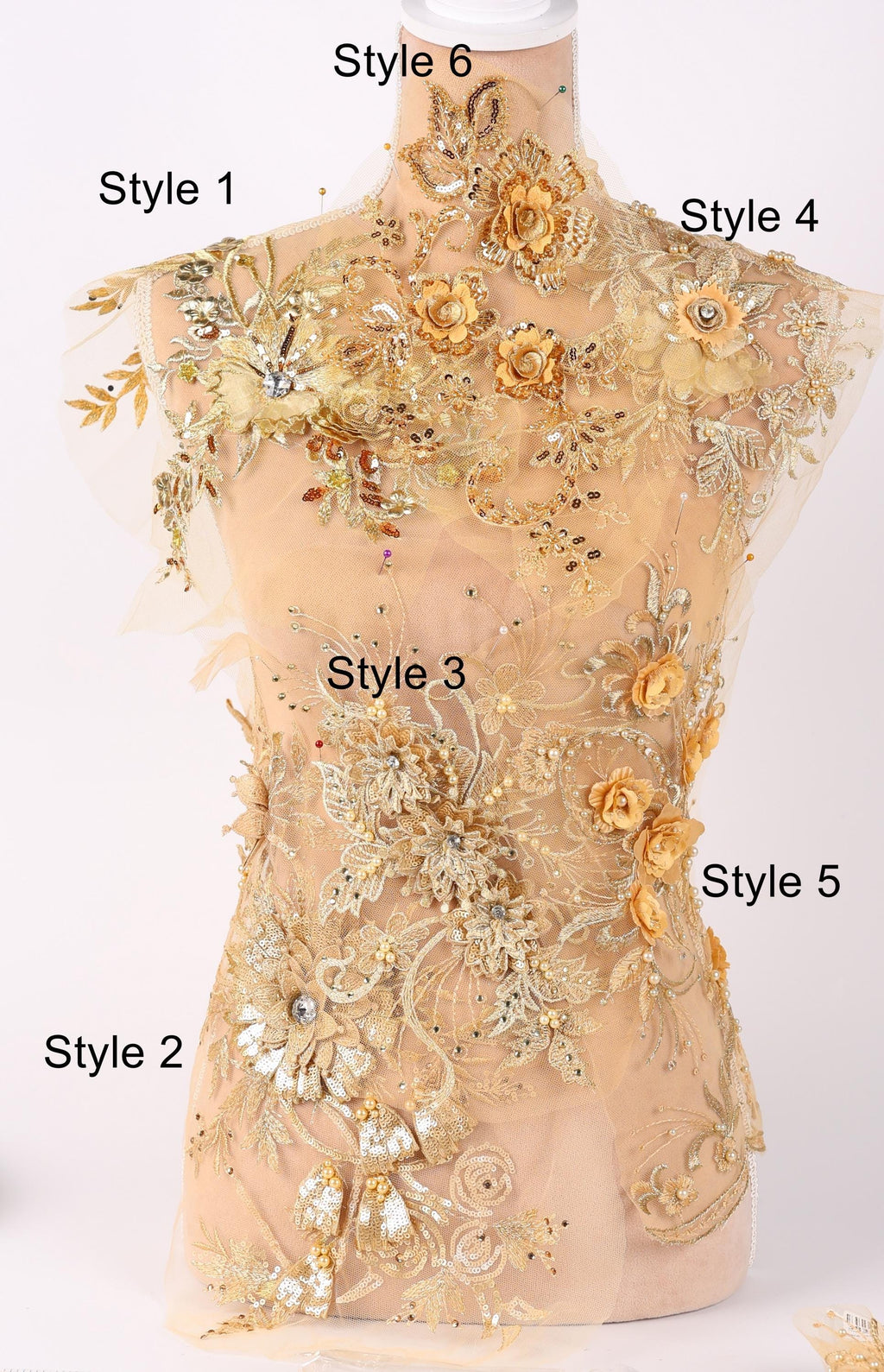 A mannequin with a beige dress adorned with intricate gold and white floral embroidery, showcasing various styles of the design.