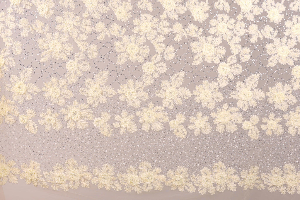 a close-up view of a delicate, intricate lace pattern with a floral design. The lace appears to be made of a fine, delicate material, possibly silk or chiffon, and is adorned with numerous small white flowers or leaves. The pattern is composed of numerous individual flowers or leaves, creating a visually striking and detailed design. The image does not contain any text or other discernible objects, and the focus is solely on the intricate lace pattern.