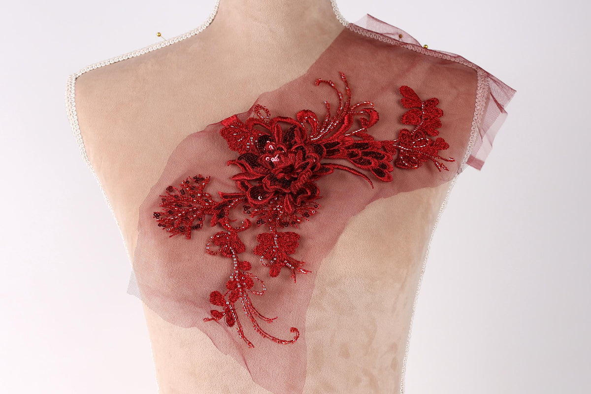 A mannequin with a red floral embroidered patch on its shoulder.