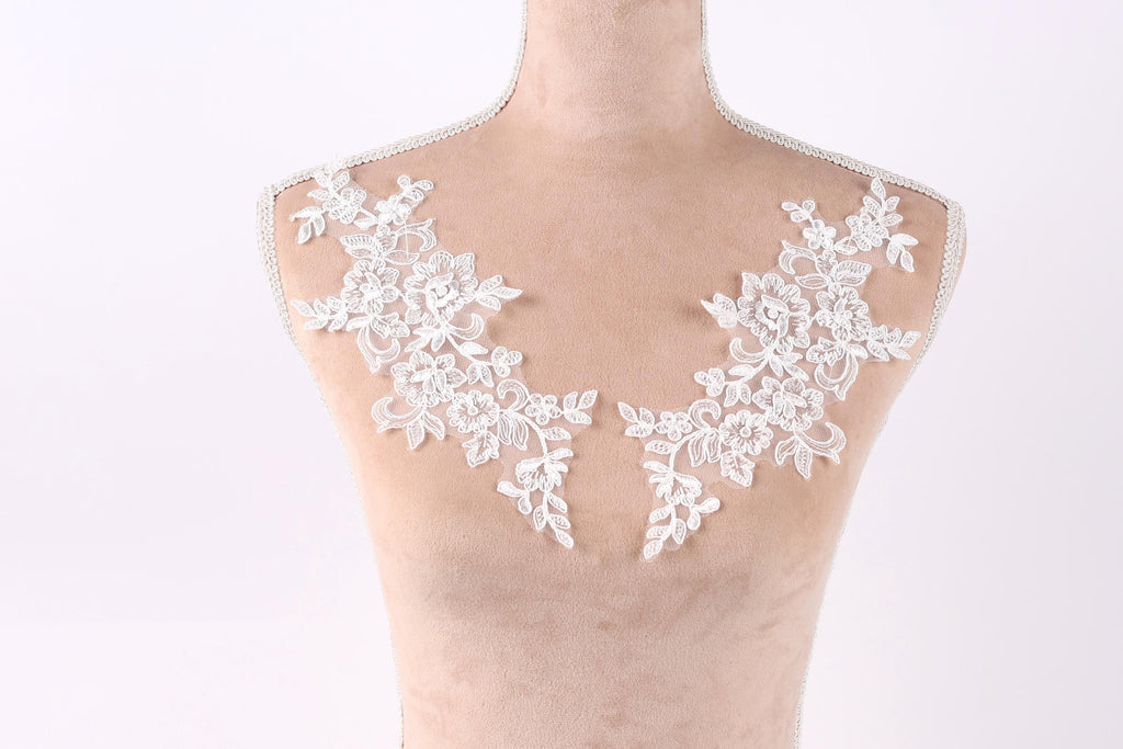 A mannequin with a white lace collar and floral embroidery on the bust area.