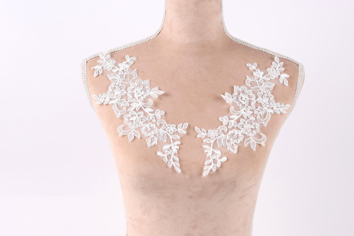 A mannequin with a white lace collar and floral embroidery on the bust area.