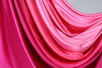 a close-up view of a fabric with a gradient of pink and red colors, creating a visually striking and vibrant appearance.