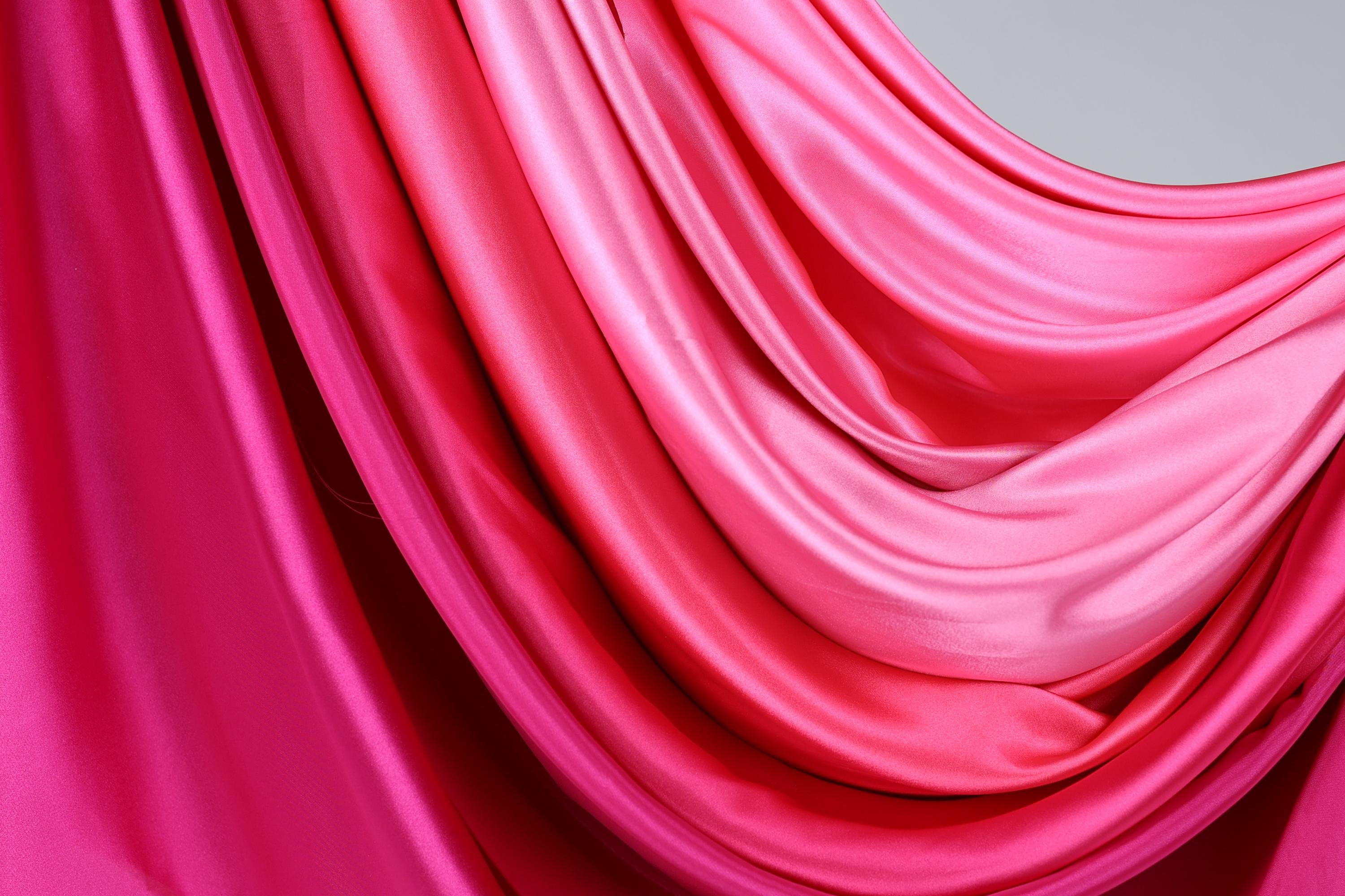 a close-up view of a fabric with a gradient of pink and red colors, creating a visually striking and vibrant appearance.