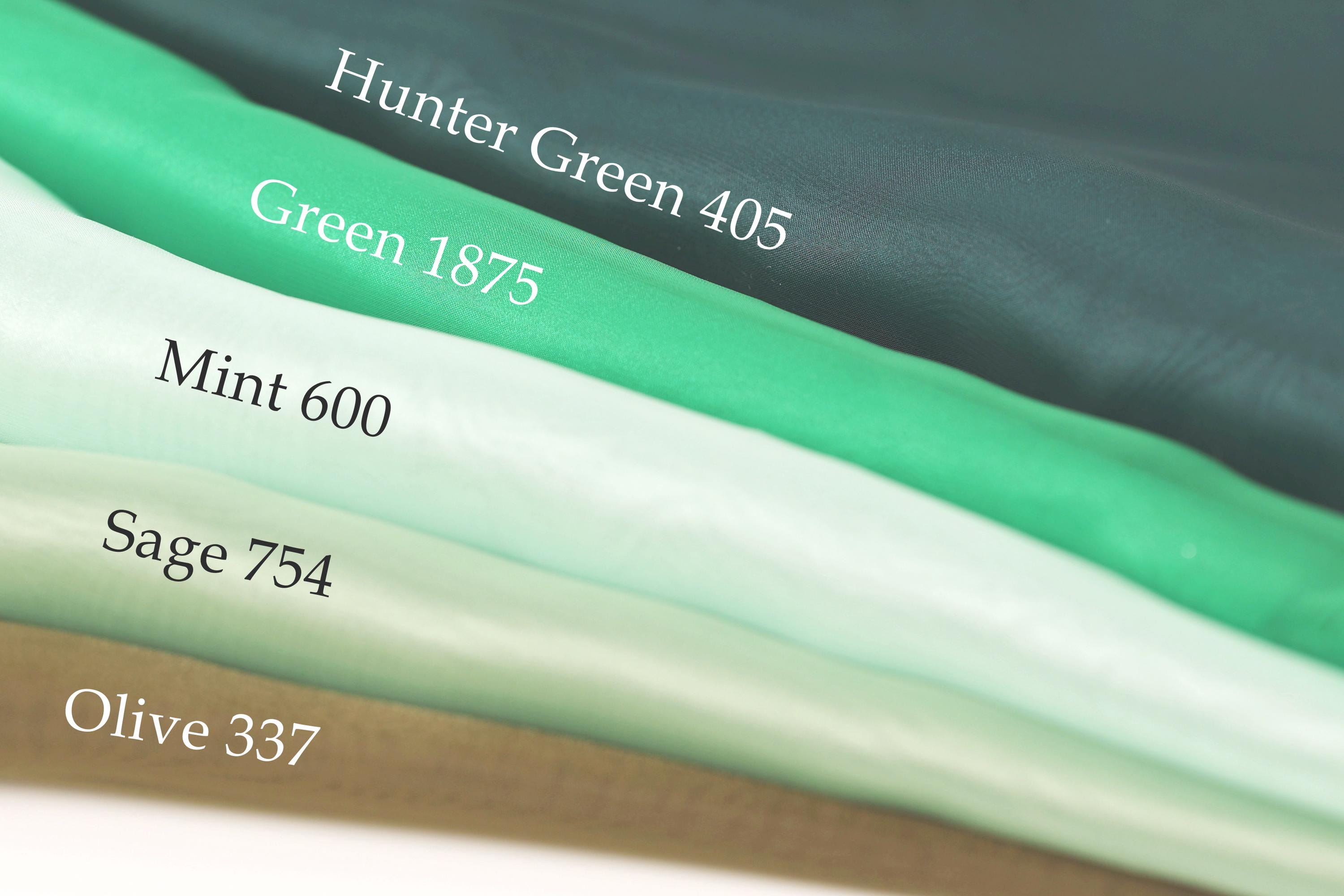 A close-up of a stack of fabric swatches, each with a different color and size, labeled with their respective names.