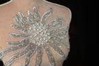 the back of a dress with a large flower on it