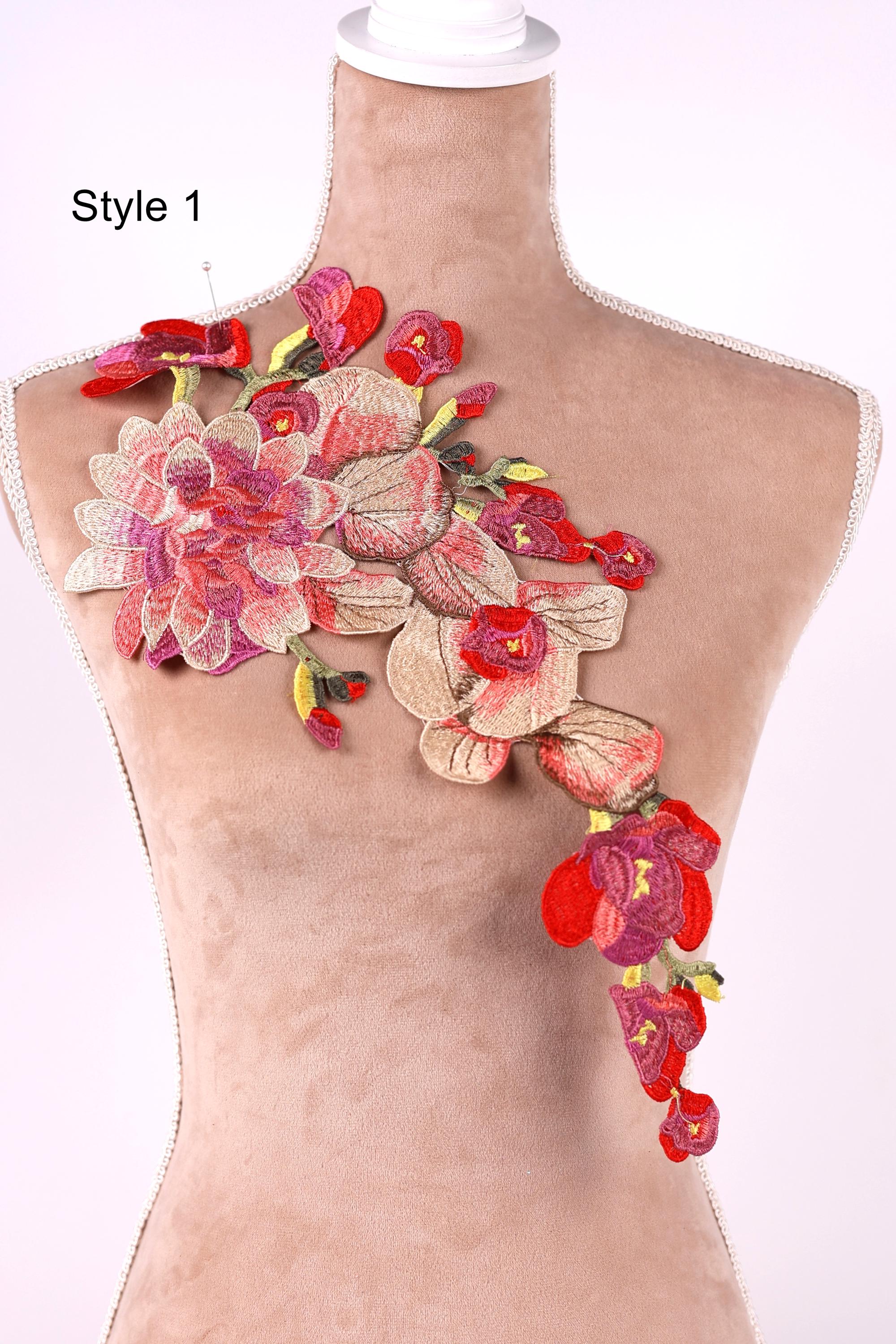 A mannequin with a floral embroidered patch on its shoulder, featuring a variety of colorful flowers including red, pink, and yellow.