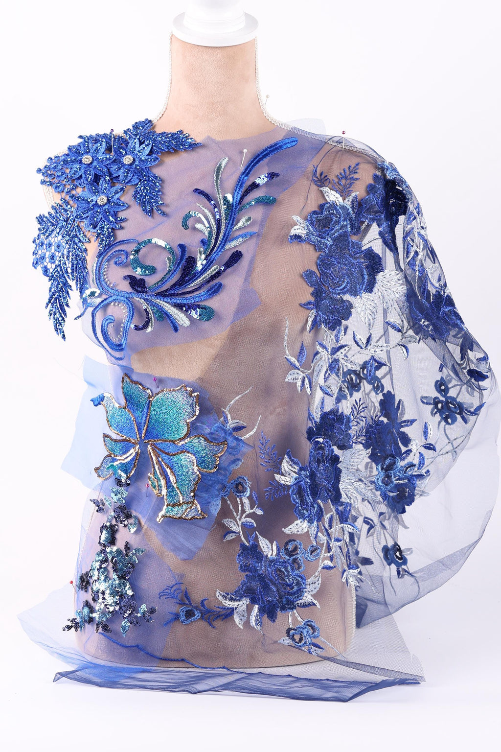 a dress with a floral pattern and blue embroidery, including a large blue flower and smaller blue flowers.