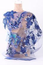 a dress with a floral pattern and blue embroidery, including a large blue flower and smaller blue flowers.