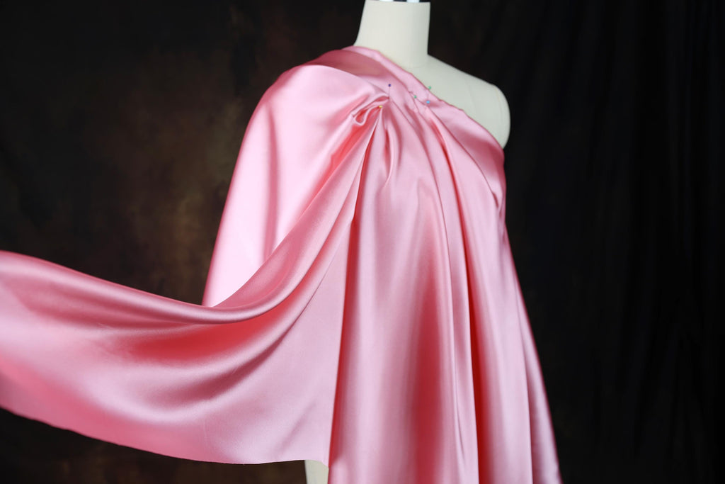 a dress on a mannequin with a pink cape
