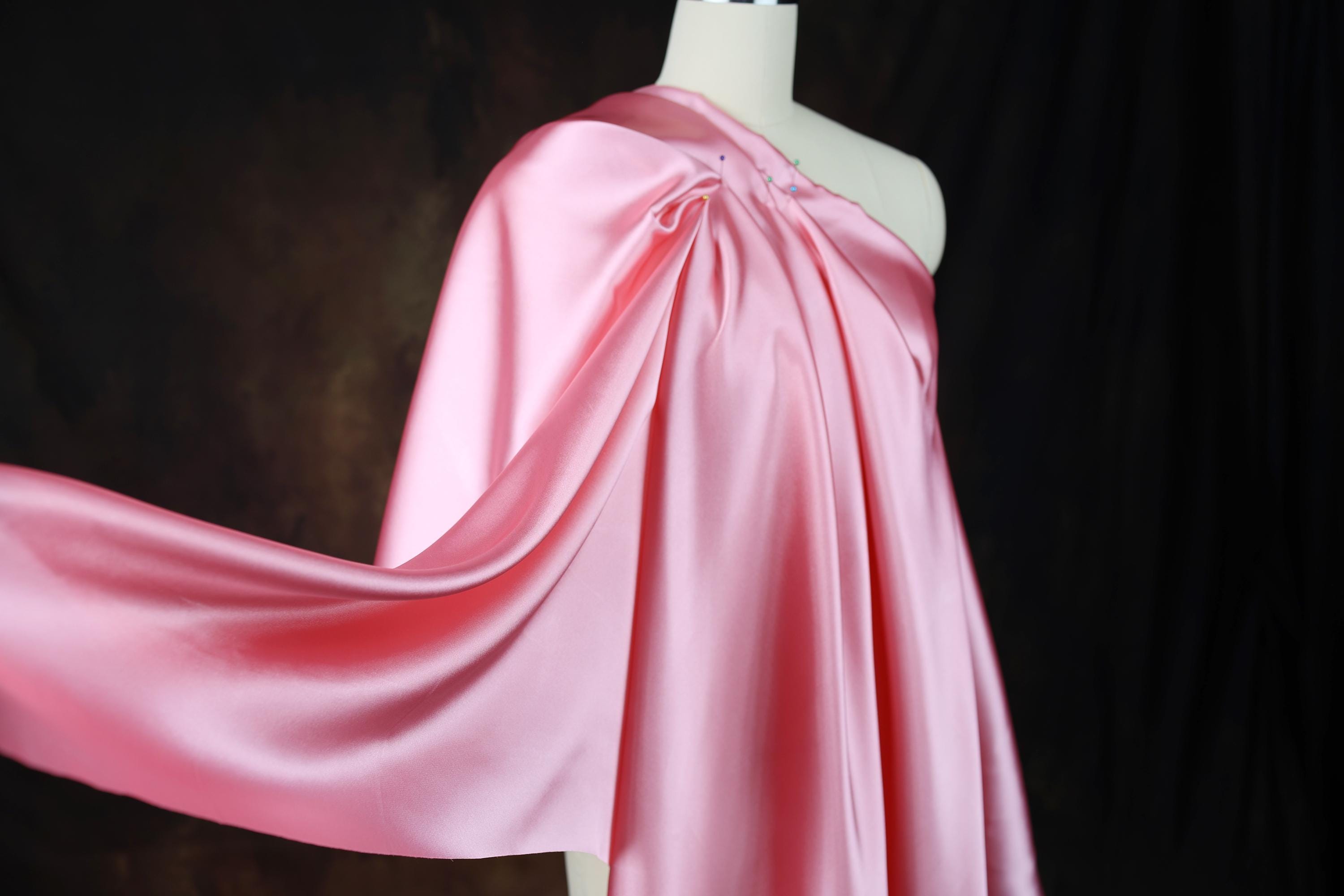 a dress on a mannequin with a pink cape