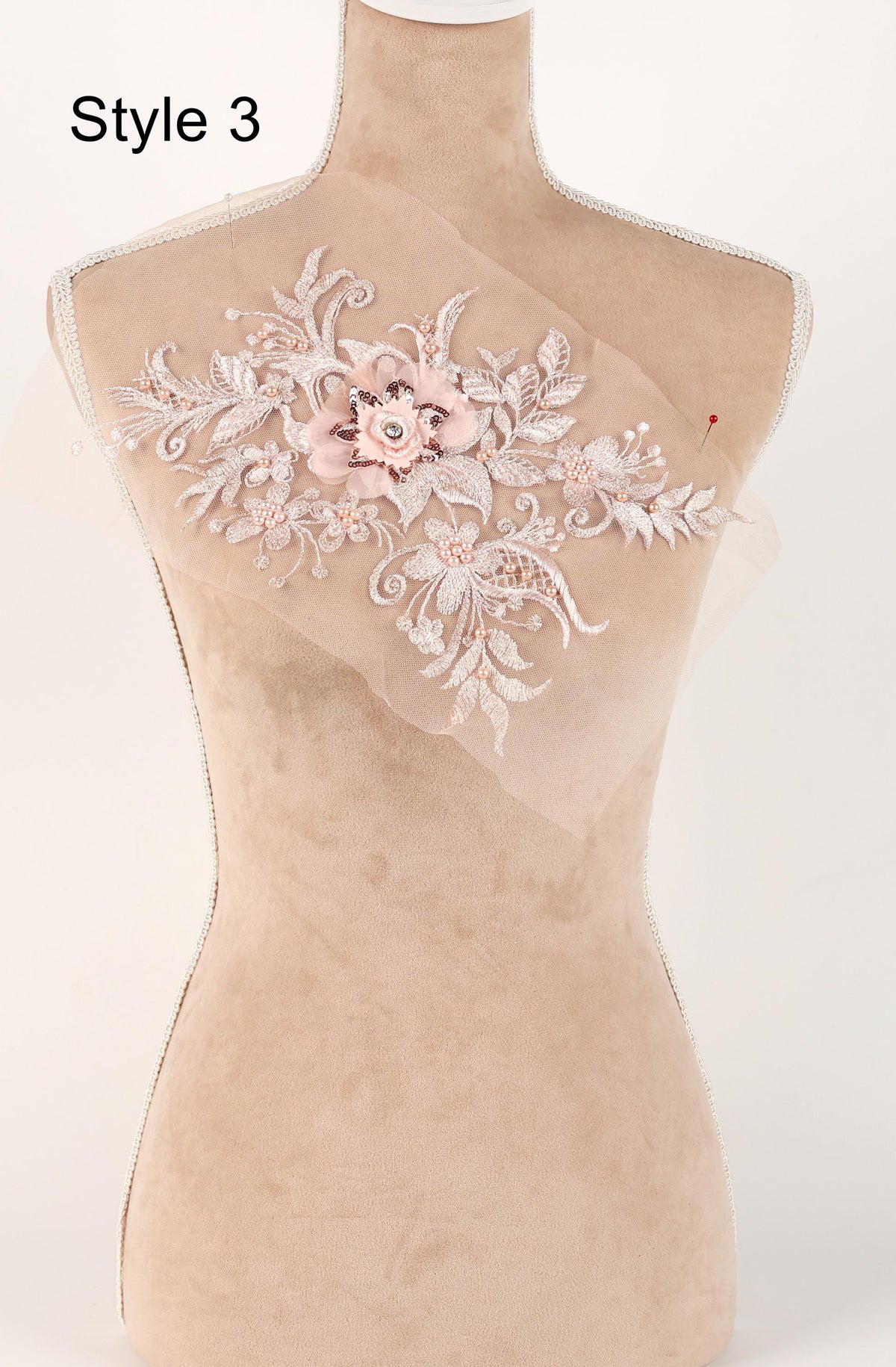 A mannequin with a decorative floral embroidery on its bust.