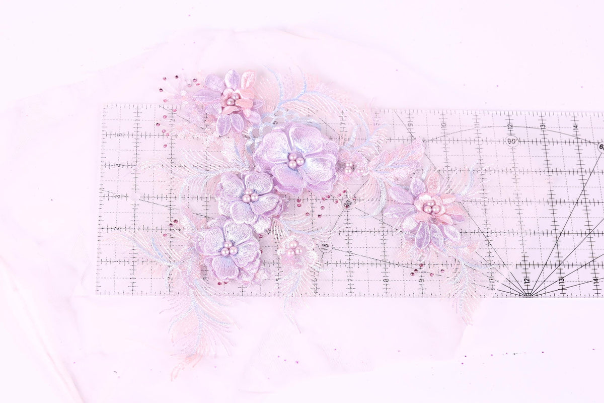 a close-up view of a delicate floral arrangement with purple flowers and leaves, placed on a transparent ruler.