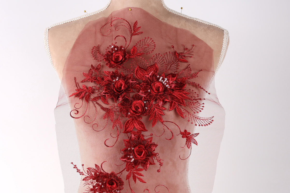 a mannequin with a red floral design on its back, including red roses and leaves.