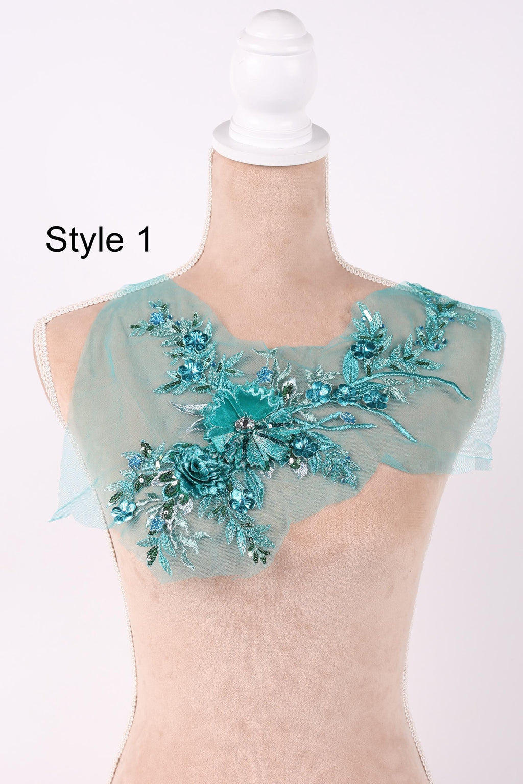 A mannequin wearing a light blue floral embroidered patch on its shoulder.