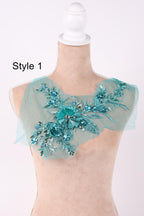 A mannequin wearing a light blue floral embroidered patch on its shoulder.