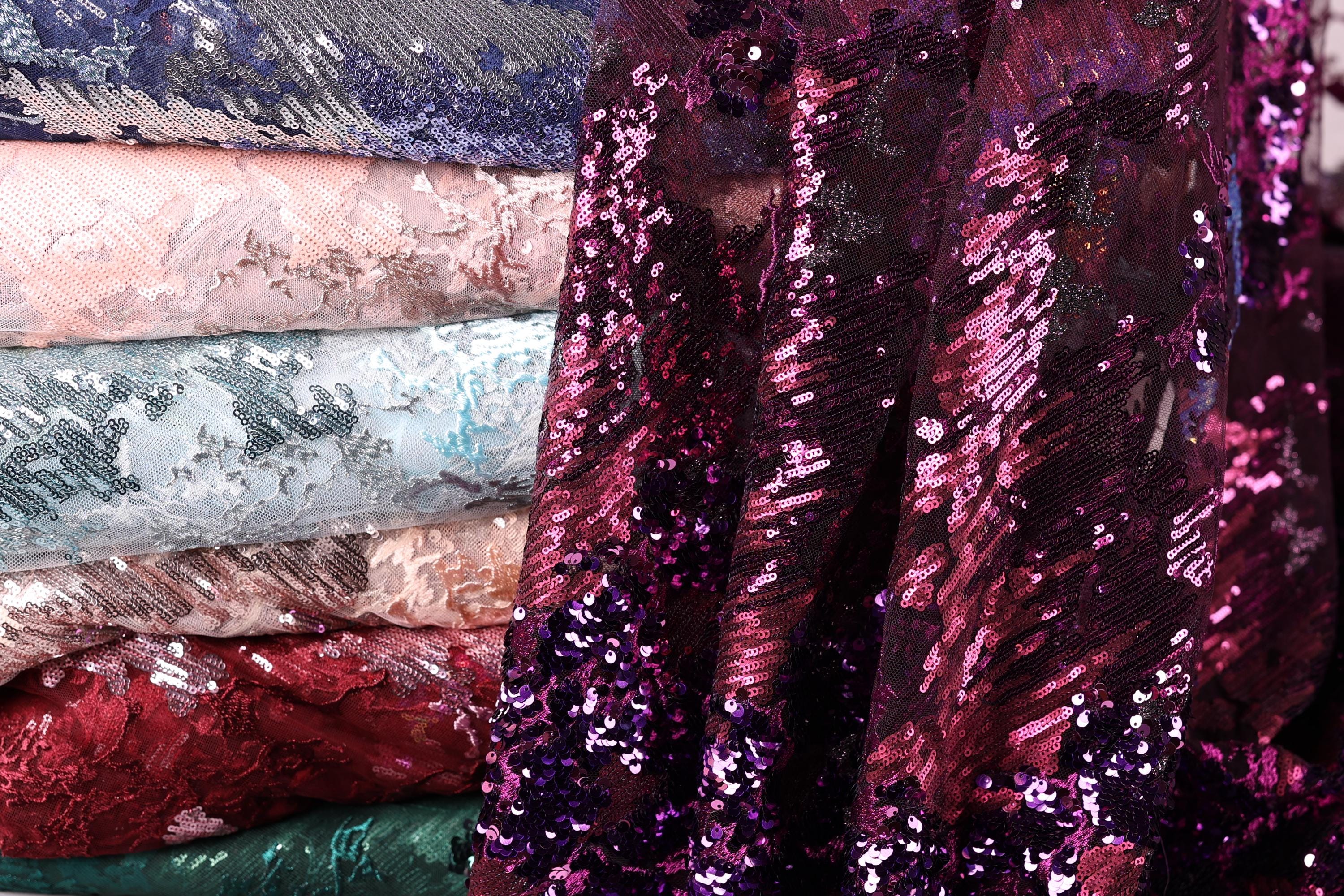 A close-up view of a pile of sequin fabric, showcasing the vibrant colors and patterns of the material.
