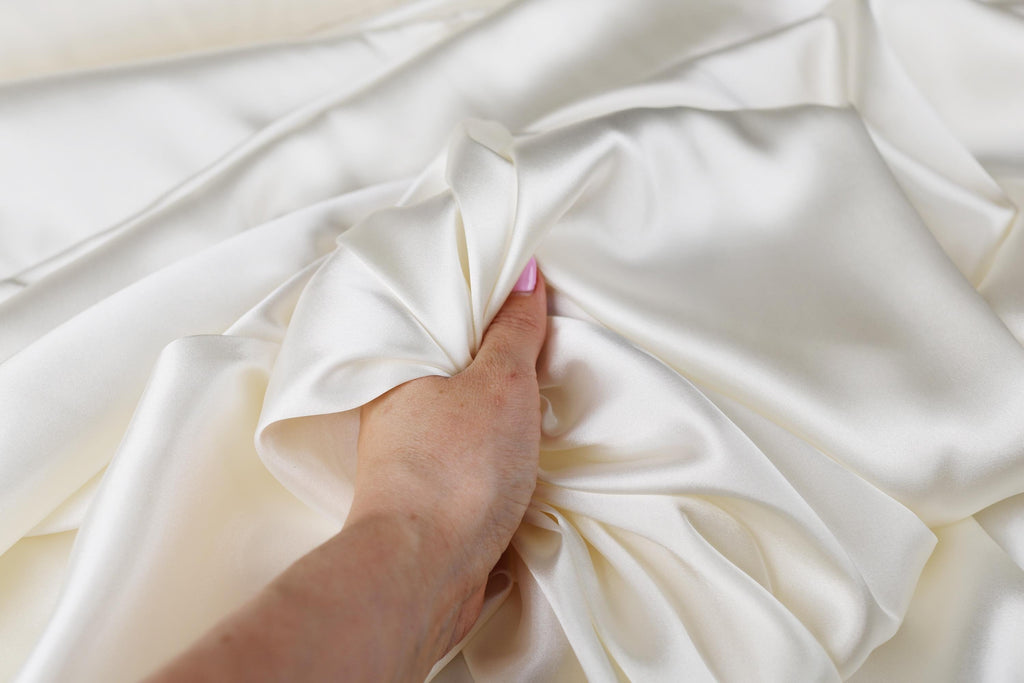 a person's hand on top of a white sheet