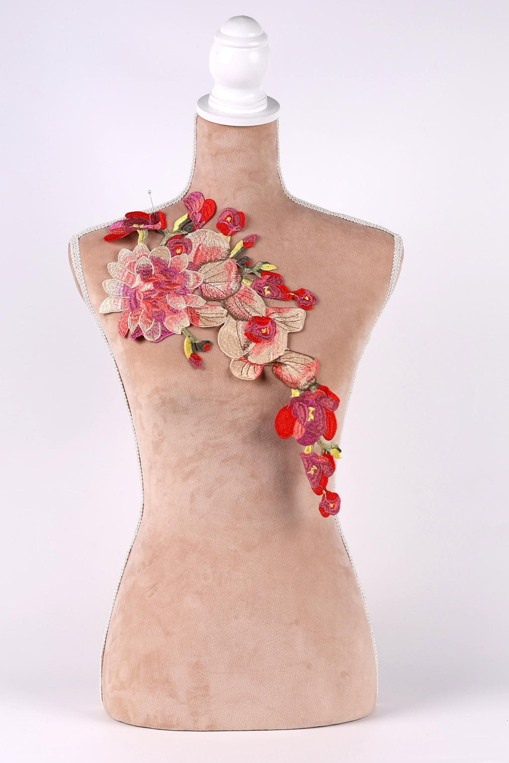 A mannequin with a floral embroidered patch on its chest.
