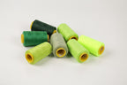 a collection of green and yellow thread spools arranged on a white background.