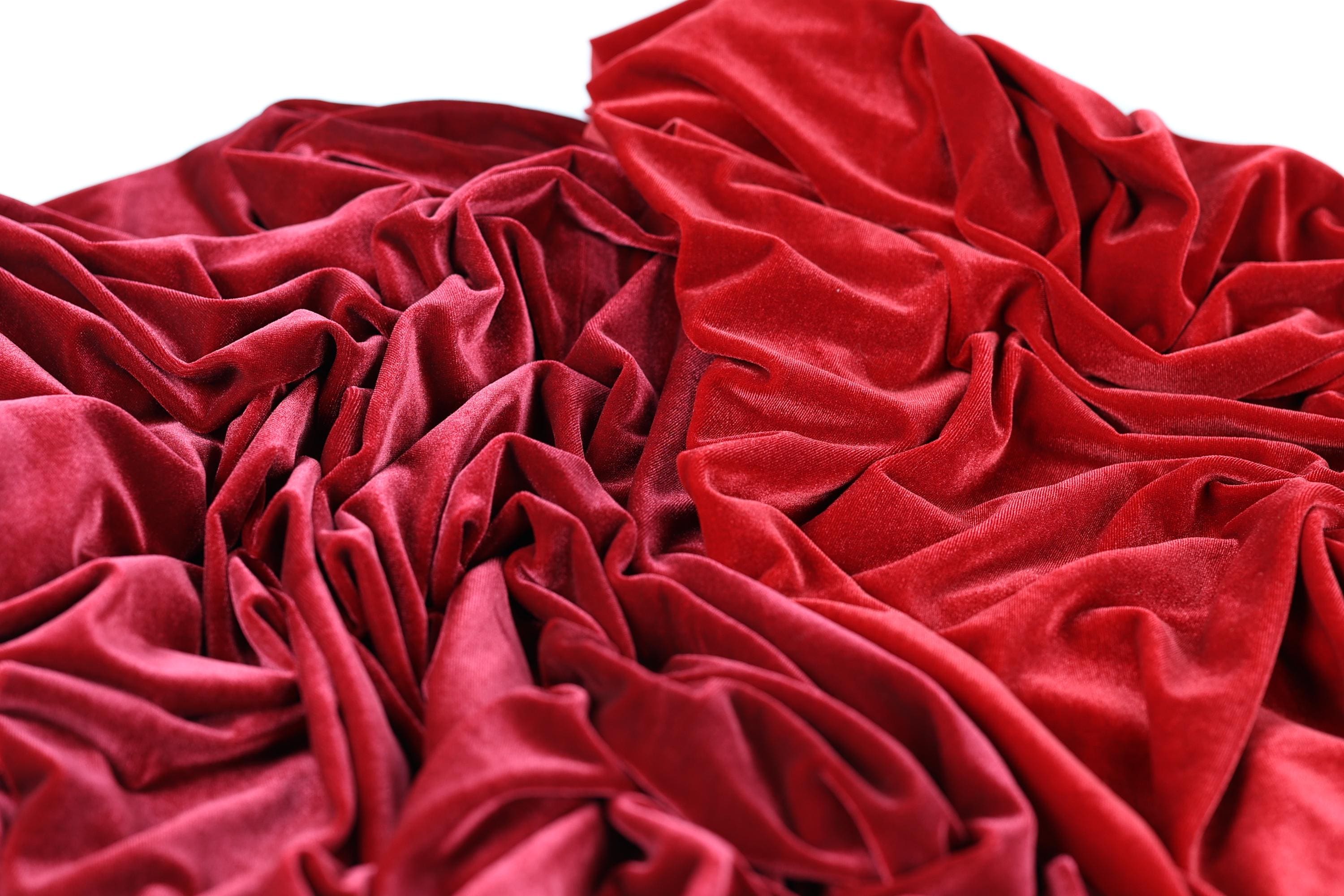 a close-up view of a crumpled red fabric, with its folds and creases creating a textured and visually interesting surface.