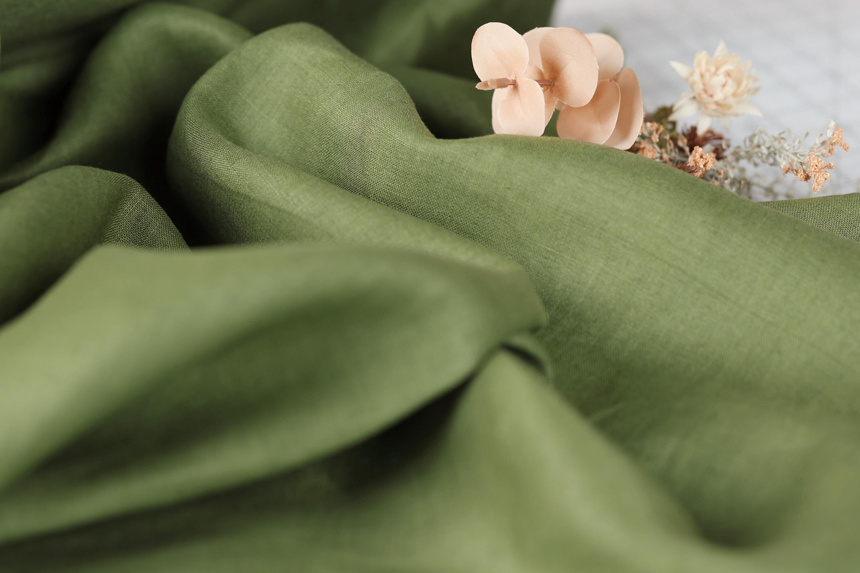 a close-up view of a green fabric with a delicate arrangement of dried flowers on top.