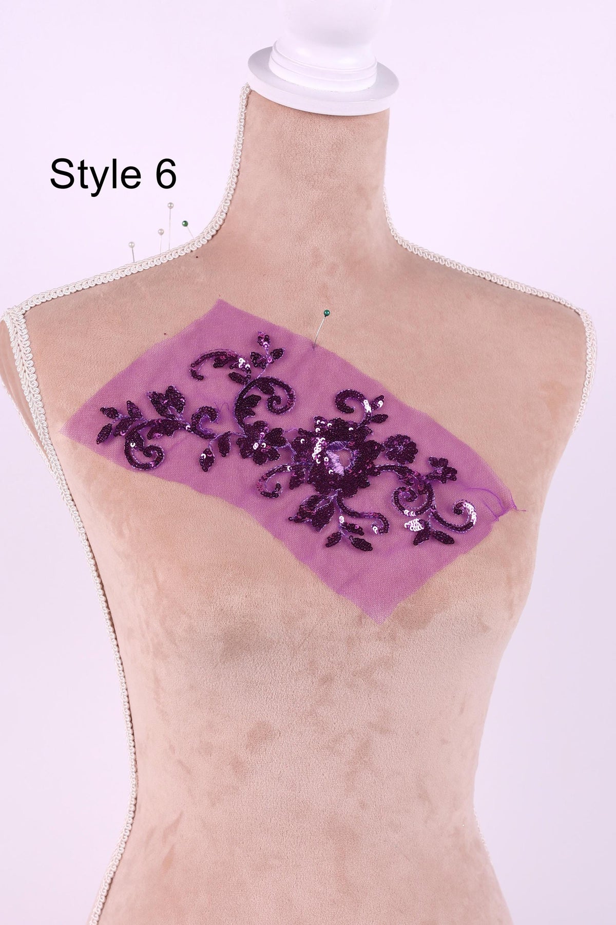 A mannequin with a purple fabric piece on its chest, featuring a floral pattern.