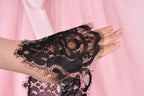 A close-up view of a hand wearing a black lace sleeve or glove, with the lace pattern visible.