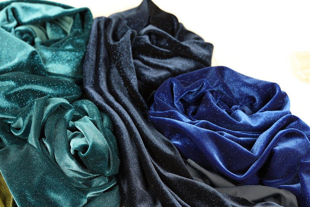 a close-up view of various textured fabrics, including blue and black materials, arranged together.