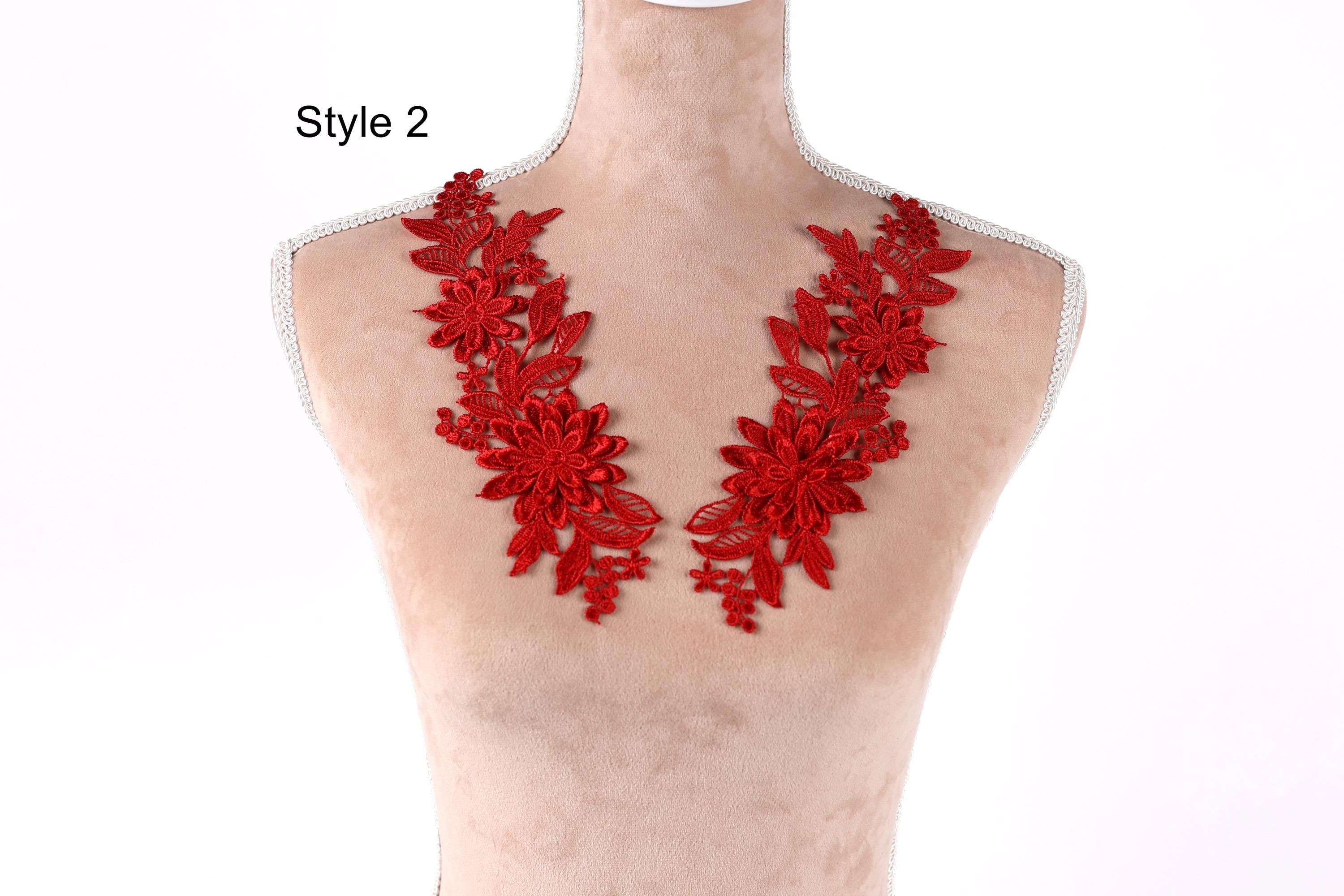 A mannequin wearing a red floral necklace with multiple flower-shaped pieces.