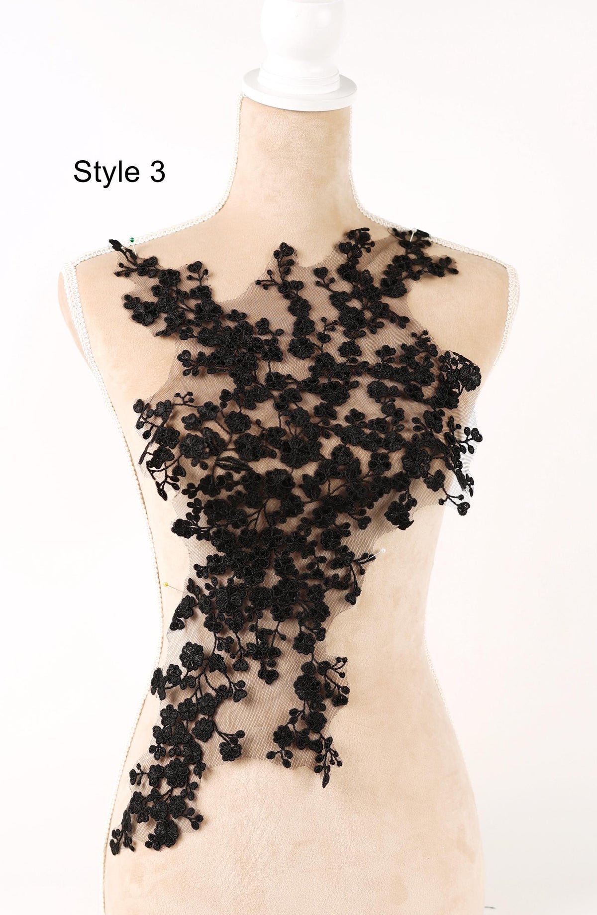 A mannequin wearing a dress with a black lace overlay.