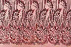 a close-up view of a fabric with a repeating pattern of red and black floral designs. The pattern consists of stylized leaves and flowers, creating a visually striking and intricate design. The fabric appears to be made of a light-colored material, which contrasts with the dark red and black colors of the floral pattern. The image does not contain any text or other discernible objects, and the focus is solely on the detailed floral design.