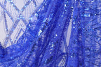 a close-up view of a fabric with a blue sequin pattern, creating a visually striking and intricate design.