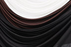 a close-up view of a fabric with a gradient of colors, including black, brown, and white. The fabric appears to be made of a soft, flowing material, possibly silk or chiffon. The colors are layered and interwoven, creating a visually appealing and textured appearance.