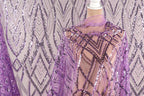 a mannequin wearing a purple sequin dress with a sheer overlay. The dress has a geometric pattern and appears to be made of sheer fabric.