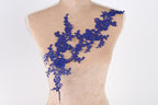 A mannequin torso with a decorative blue lace overlay on it.