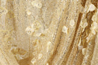 The image is a close-up of a fabric with a gold and white color scheme, featuring a floral pattern and sequin accents.