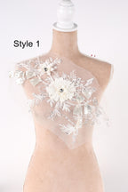 A mannequin wearing a white dress with a floral design on the bust.