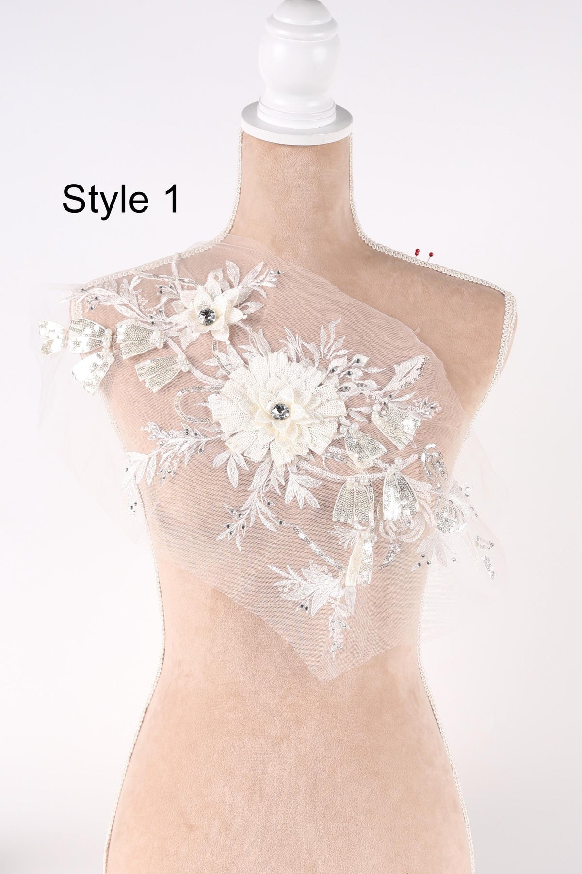A mannequin wearing a white dress with a floral design on the bust.