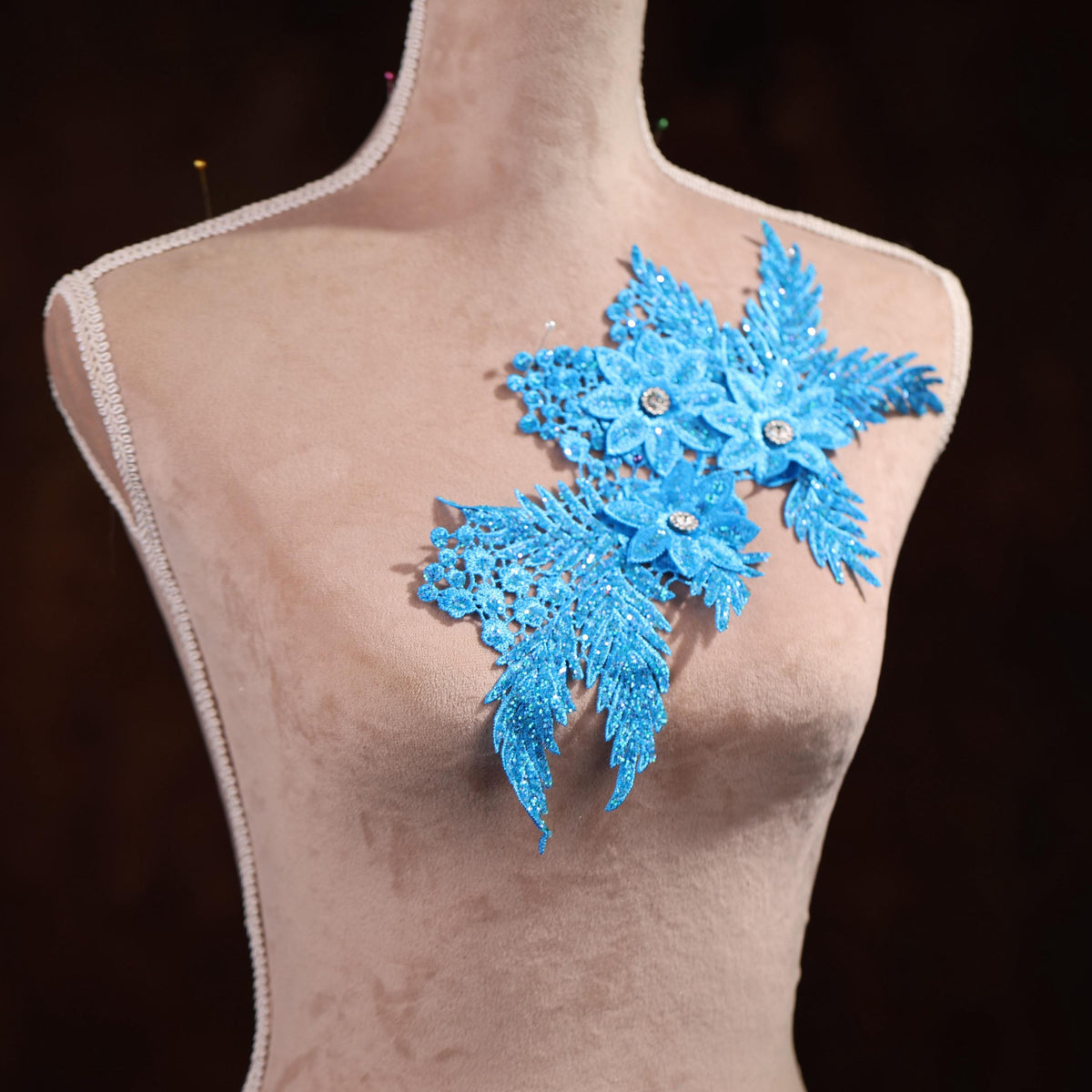 a mannequin with a blue snowflake brooch on it
