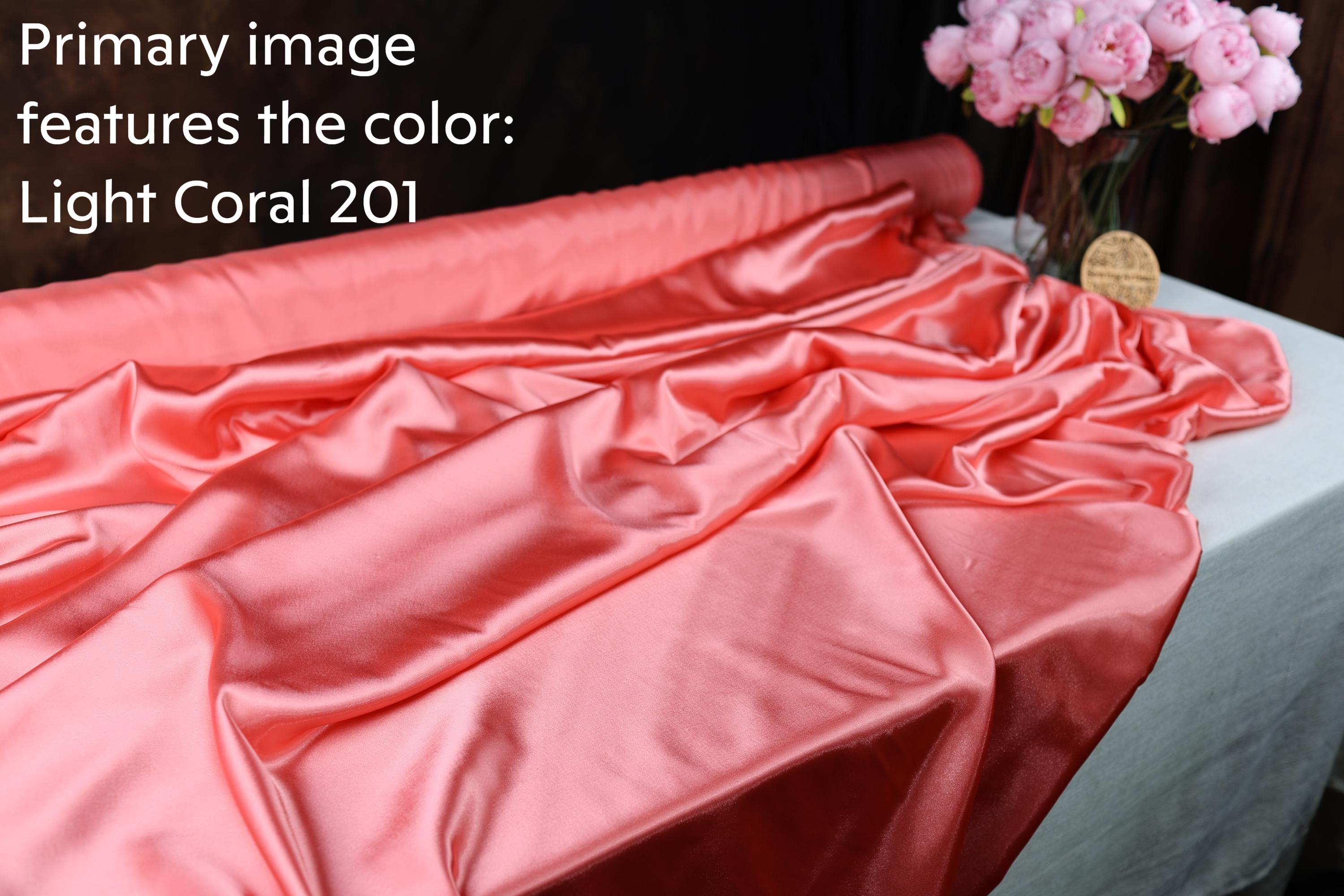 a close-up view of a crumpled, pink satin fabric with the text &quot;Light Coral 201&quot; written on it.