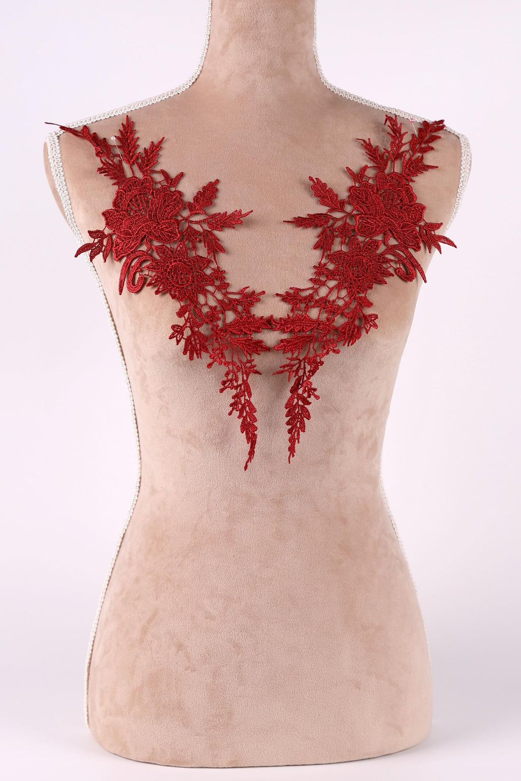 A mannequin torso with red floral embroidery on the bust area.