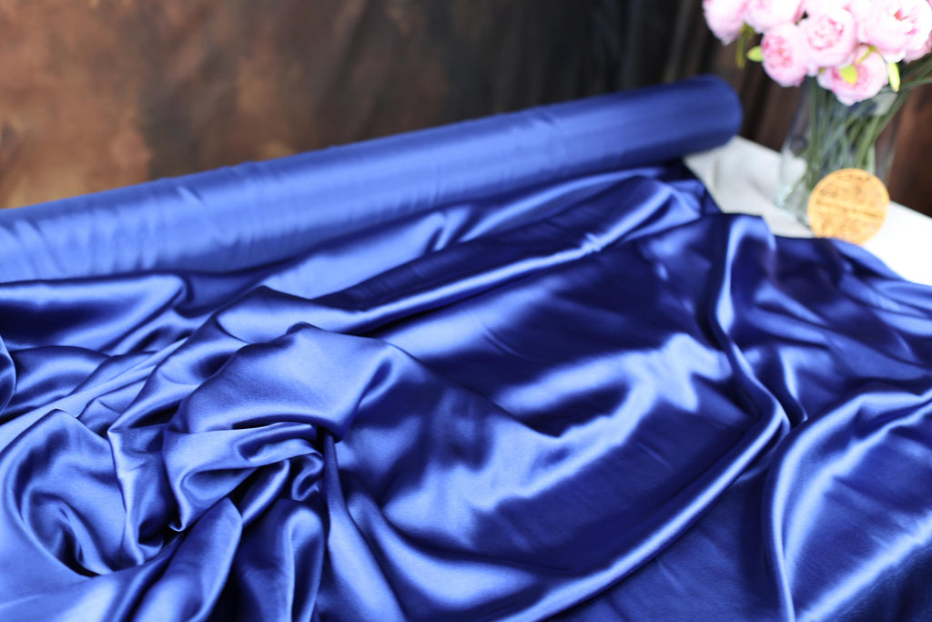 a vase filled with pink flowers sitting on top of a blue cloth