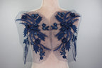 A mannequin wearing a dress with a blue floral pattern on the shoulders and back.
