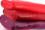 three different colored fabric rolls stacked on top of each other, with each roll labeled with a different color and size.