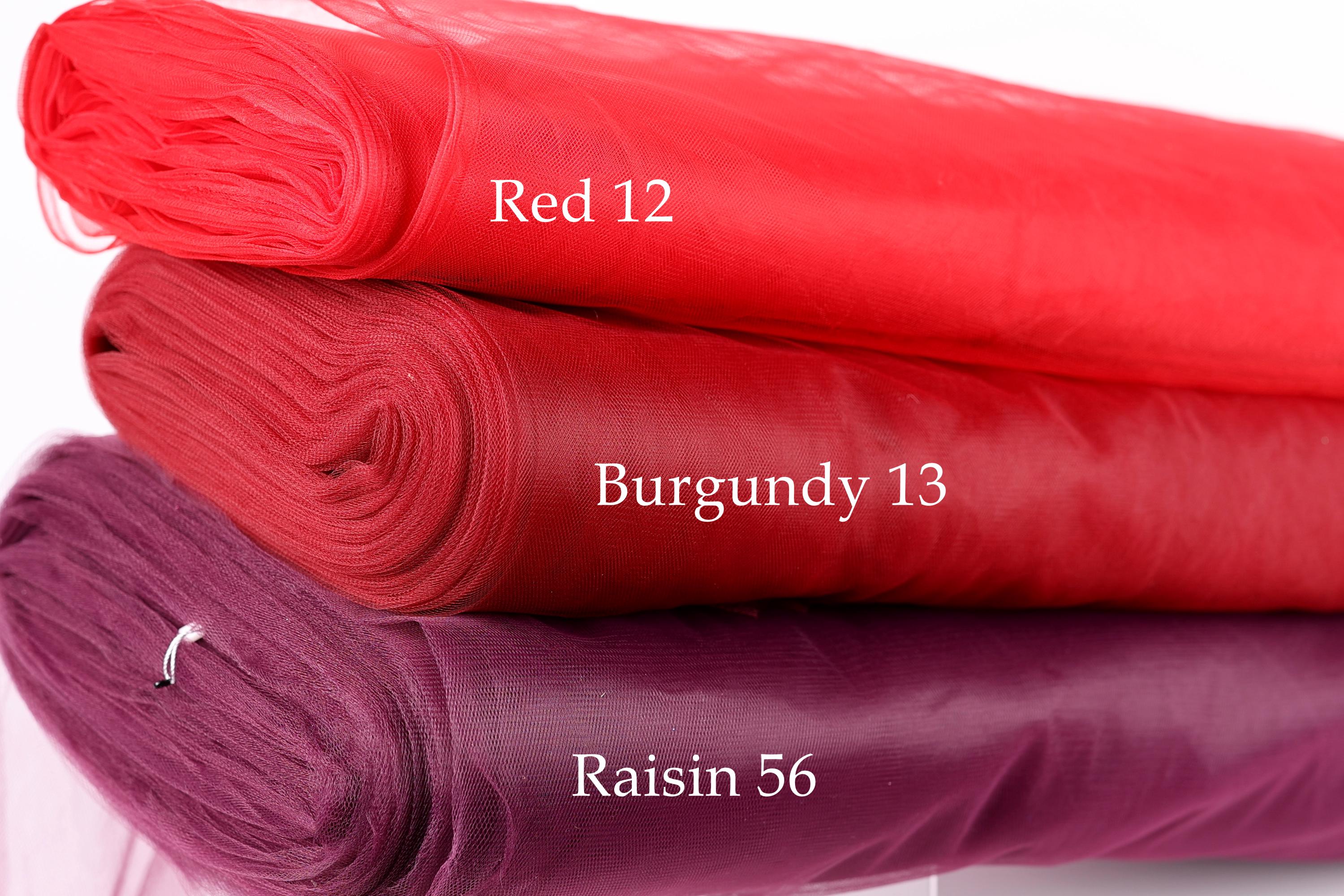 three different colored fabric rolls stacked on top of each other, with each roll labeled with a different color and size.