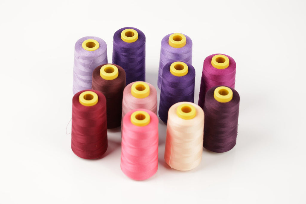 a collection of colorful spools of thread arranged in a circular pattern on a white background.